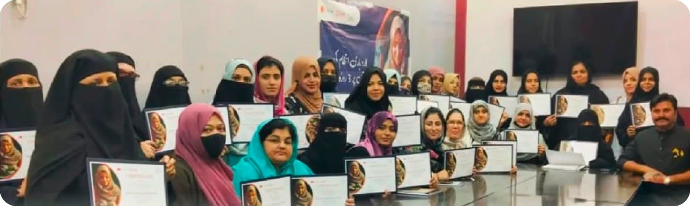 A wide group photograph of graduates with their certificates